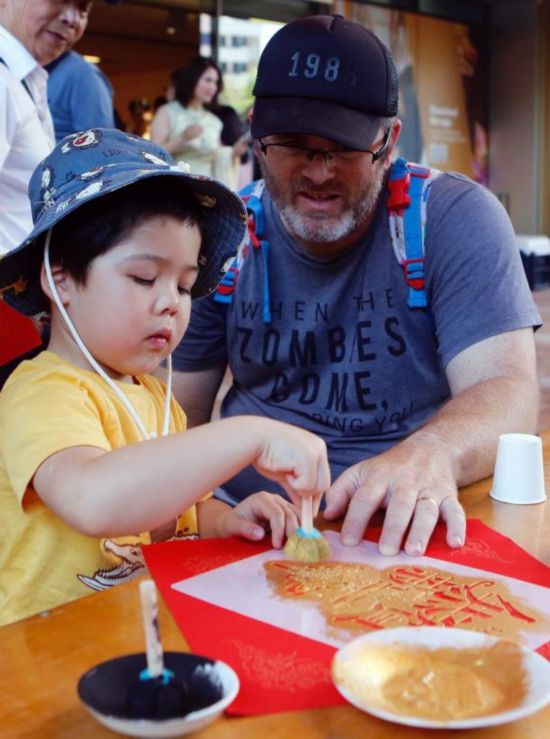 2月1日，在澳大利亚珀斯的西澳大利亚博物馆，当地儿童在家长陪同下拓印新年福贴。（周丹 摄）