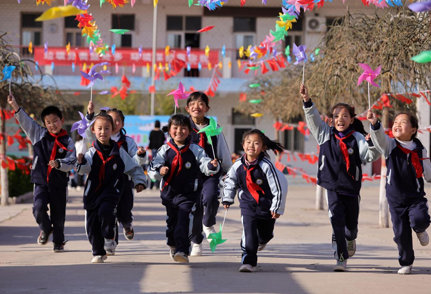 河北省邢台市广宗县第六小学学生手握风车，快乐奔跑。 王垒摄