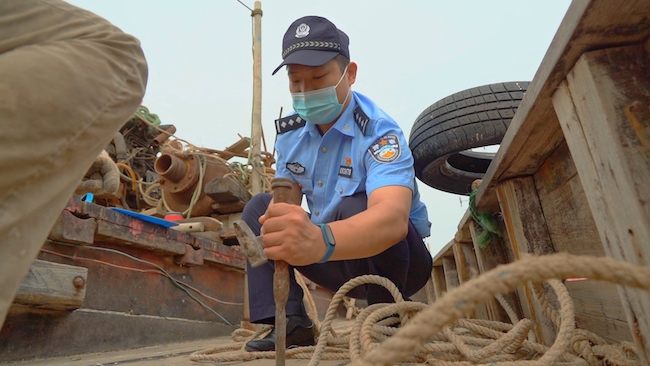 刘春鹏帮助渔民修补船只。 王爱民摄