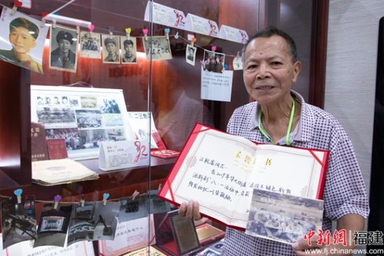 4、退役军人江乾富向记者展示自己珍藏多年的老照片和老物品。苏新宏 摄