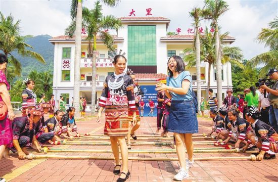 大里村民舞蹈队带领游客一起跳竹竿舞。 记者 武威 摄