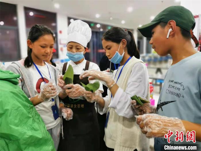 西藏加查县中学学生赴宜昌开展研学旅行，学习包粽子(资料图) 湖北省援藏办供图