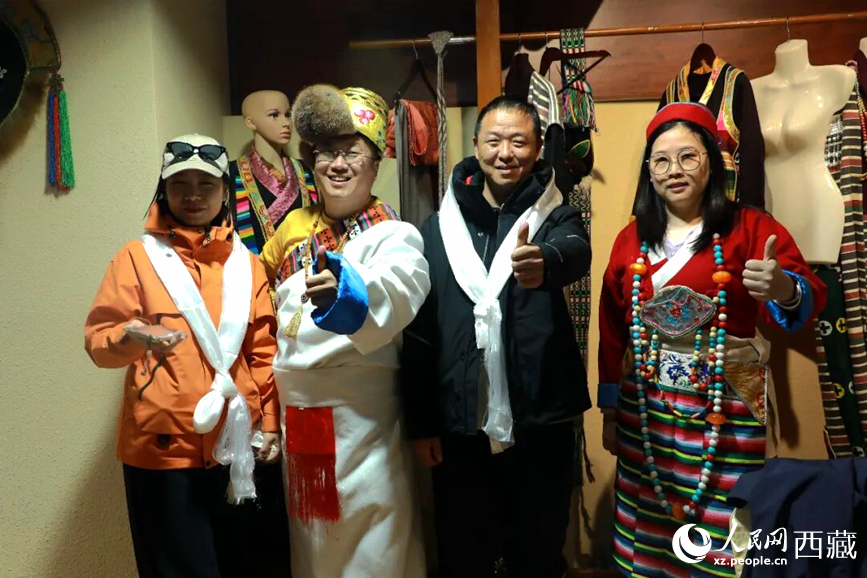 游客在扎西曲登社区体验藏族服饰文化。大家身着色彩鲜艳的藏装，佩戴特色饰品，脸上洋溢着喜悦的笑容。人民网记者 吴雨仁摄