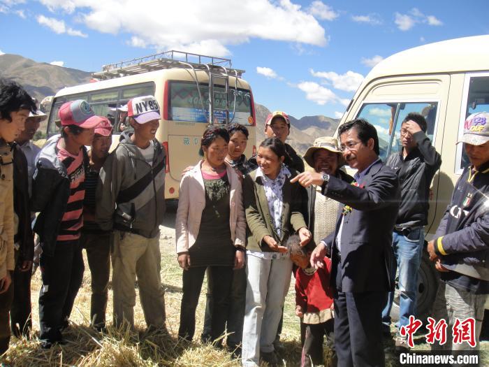 图为尼玛扎西(右三)在下乡途中与指导农民种植(资料图)。西藏农科院 供图