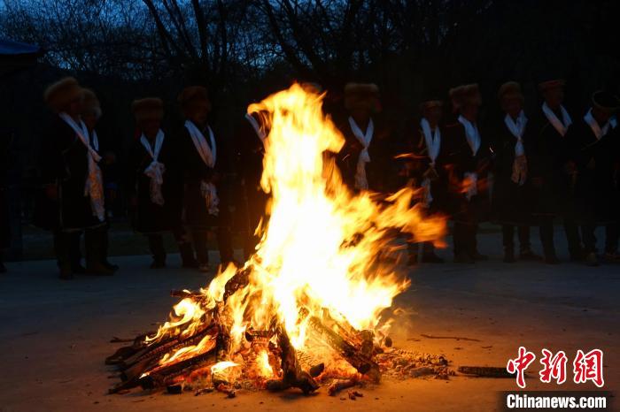 图为人们围着篝火跳起锅庄。　冉文娟 摄