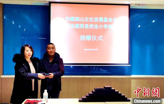 图为西藏高山文化发展基金会理事长温丽向聂荣县完全小学负责人捐助仪器。　于宾 摄