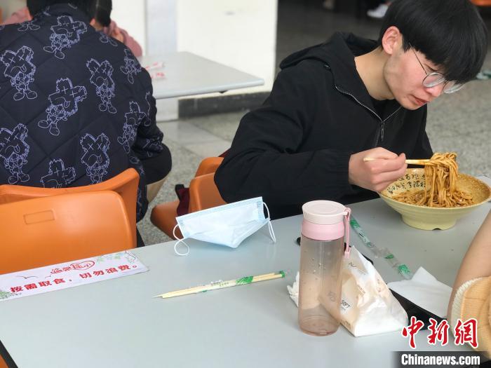 3月17日，西藏大学学生正在学校食堂用餐，餐桌上写着“按需取餐，切勿浪费”。　冉文娟 摄