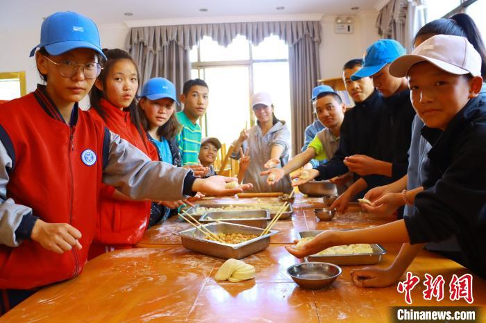 图为学生们在西藏巴松措青少年活动营地一起包饺子。　西藏青少年实践教育基地供图