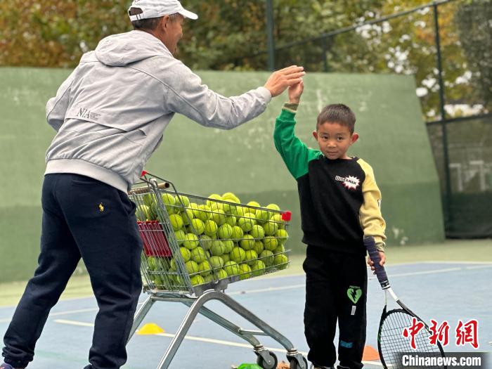 图为王发六岁的弟弟王艺正在教练的指导下练习网球动作。　郑晨子 摄