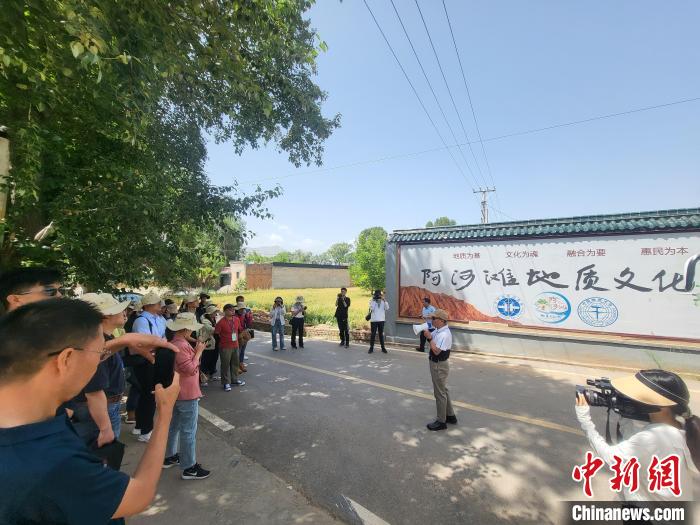 图为中国地质大学(北京)教授张绪教介绍村落情况。　胡友军 摄