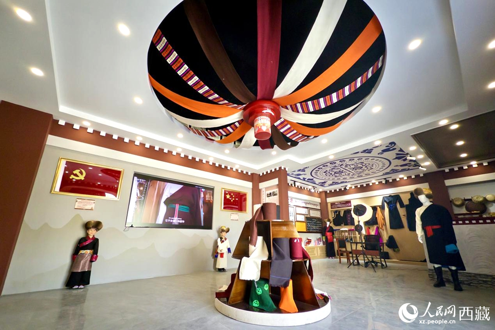 图为克西氆氇文化传承馆内部,穹顶设计色彩斑斓,展陈着精美的传统服饰与文创产品。人民网记者 次仁罗布摄