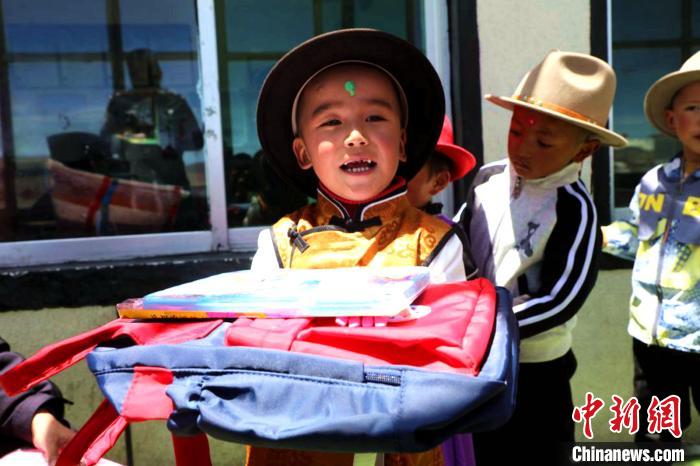 图为普玛江塘乡小学生领取书包等学习用具。　浪卡子县网信办供图