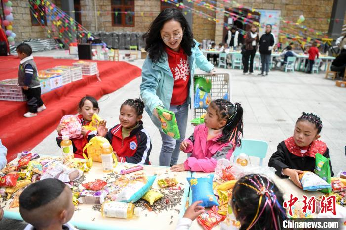 湖南援藏队的代表魏昕来到玉麦乡小学为小朋友赠送儿童节礼物。　杨华峰 摄