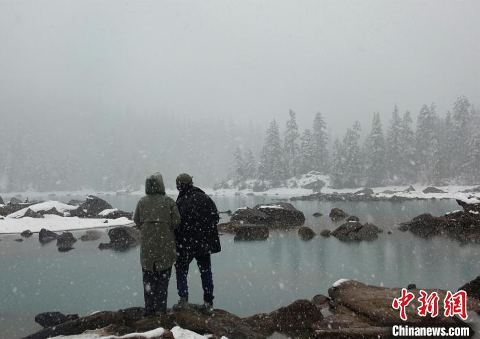 游客欣赏雪中然乌湖。　冉文娟 摄