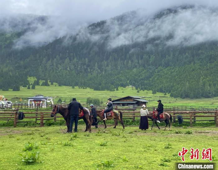 6月10日，游客在鲁朗小镇高山牧场景区体验骑马。　冉文娟 摄