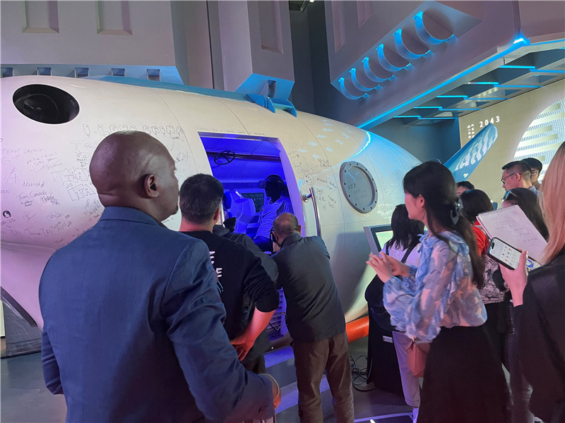 (中外记者在元宇宙数字文旅产业园内体验SoReal“蛟龙”号载人深海模拟体验器 赵橙涔摄)