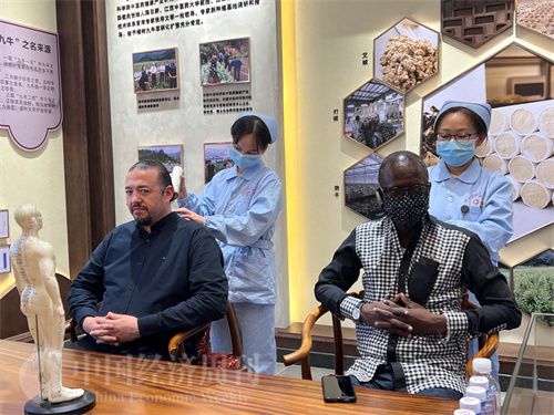 (外媒记者争先恐后体验艾灸,直呼神奇。中国经济周刊记者 郭志强 摄)
