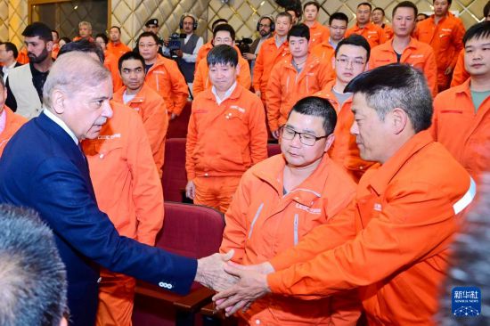 4月1日,在巴基斯坦西北部开伯尔-普什图省达苏,巴基斯坦总理夏巴兹(左)同达苏水电站项目中方员工握手。新华社发(巴基斯坦新闻与广播部下辖媒体信息部门供图)