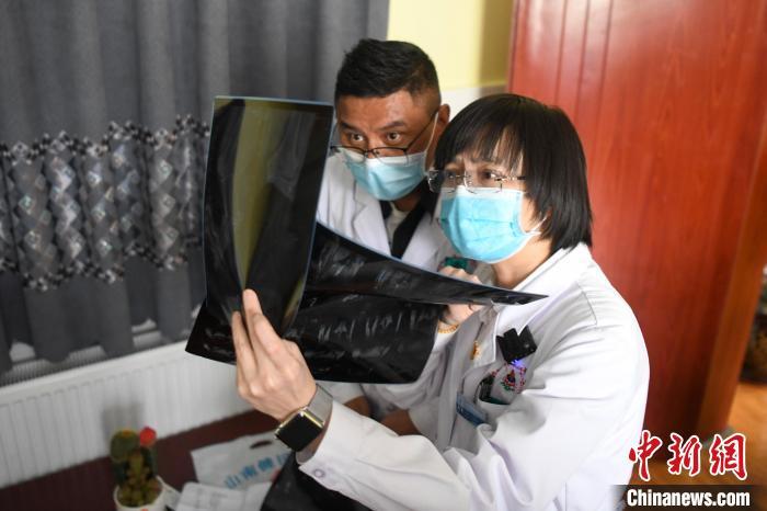 湖南中医药大学第一附属医院外治科援藏医生谭涛(右)与学生边巴云旦一起为患者进行治疗。　杨华峰 摄