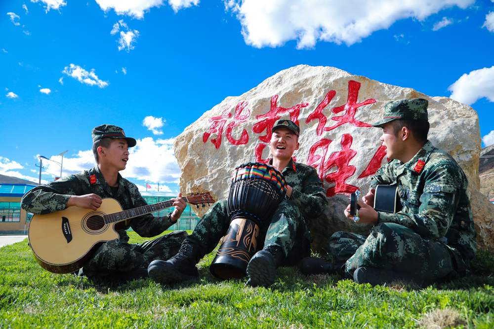 官兵正在弹奏自编歌曲《青春高原》。