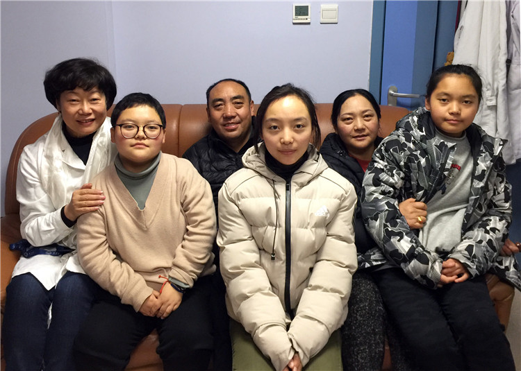 这是西藏那曲市索朗旺堆（左三）和妻子西嘎措姆（左五）及他们的大女儿欧珠旺姆（左二）、二女儿洛珠巴姆（左四）、三女儿巴桑拉姆（右一），一家五口人在北京安贞医院顾虹办公室与顾虹（左一）合影留念（唐召明提供，2019年1月17日摄） .jpg