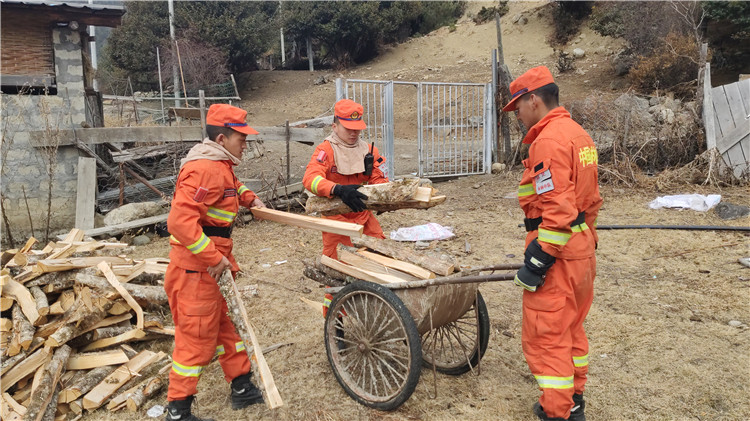 图为李庆正带着指战员们帮助驻地居民整理木柴.jpg
