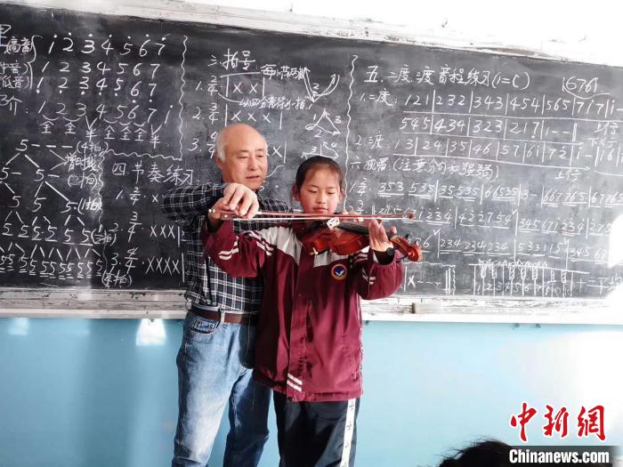 图为赵兴洲教学生拉小提琴。受访者提供