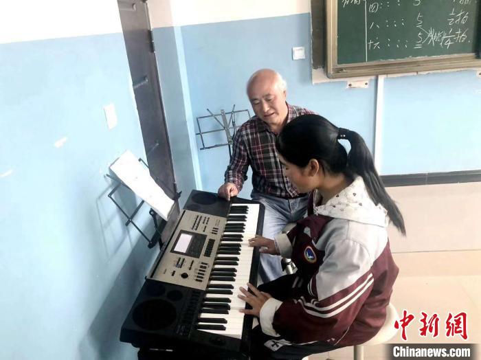 图为赵兴洲教学生弹电子琴。受访者提供