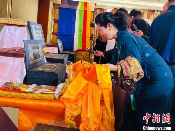 图为现场藏族民众向黄金书写的大藏经《甘珠尔》敬献哈达。　孙睿 摄