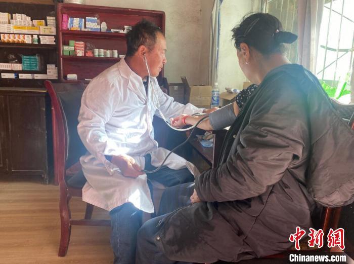 索木滚(左)为村民看病。　壤塘县委宣传部供图