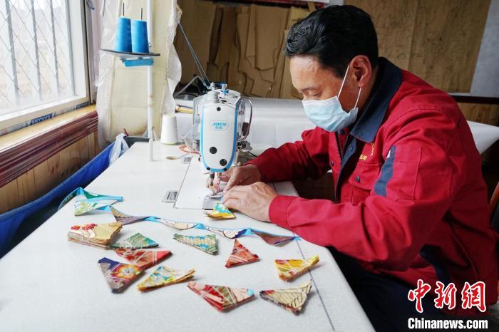 图为工人正在制作藏式手工艺品。　马铭言 摄