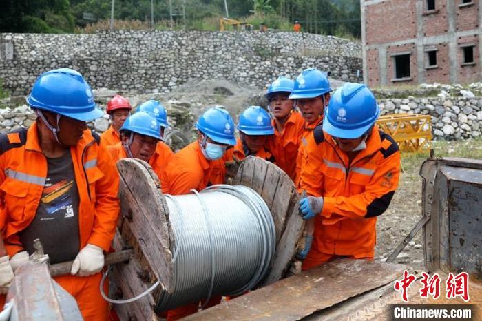 国网四川送变电公司抢险队员将重达370公斤的钢绞线搬上车。　刘湘钒 摄