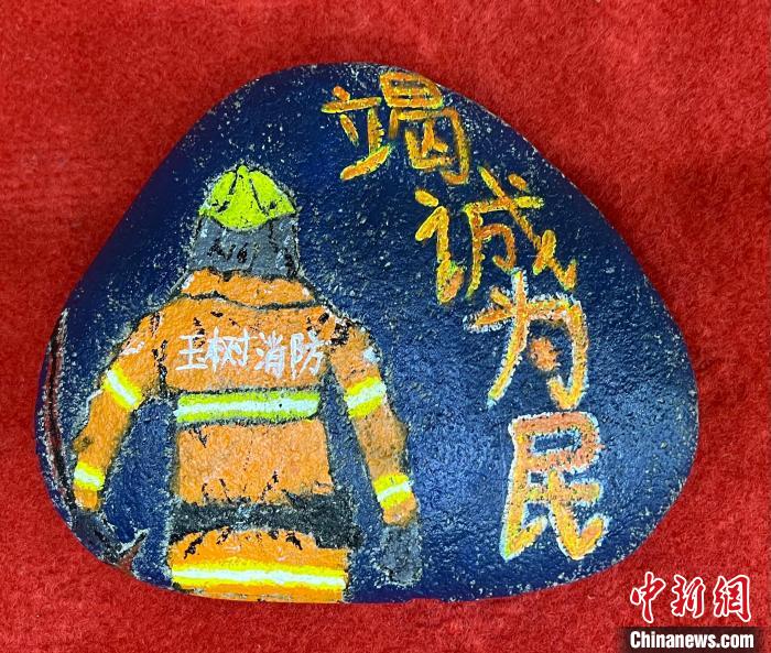 图为玉树消防指战员创作的石头画作品《逆行在路上》。　孙瑞祥 摄