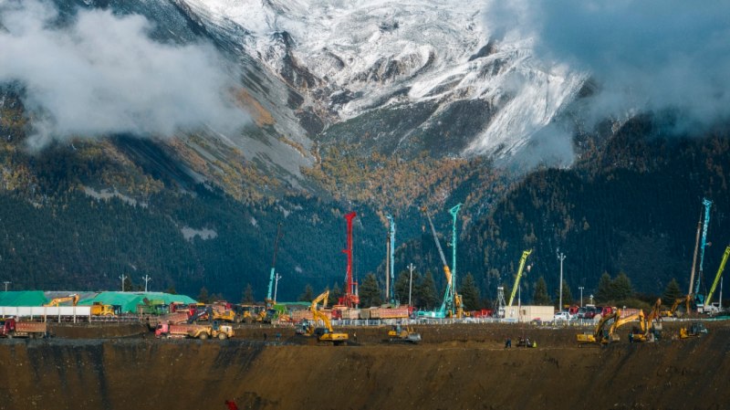 10月25日，在阿坝1000千伏变电站建设现场，多彩的作业机械与洁白的雪山交相辉映。国网四川建设公司供图