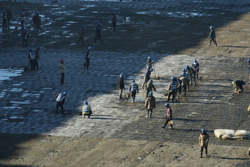 10月28日，在阿坝1000千伏变电站建设现场，作业人员正在清理雪后填方坡区域的积水。国网四川建设公司供图