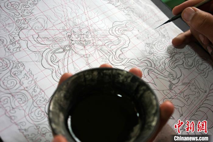图为唐卡绘画班学员按《造像度量经》绘制唐卡。　江飞波 摄
