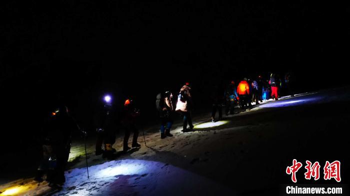 图为5日凌晨出发的登山者在攀登洛堆峰途中。　张伟 摄