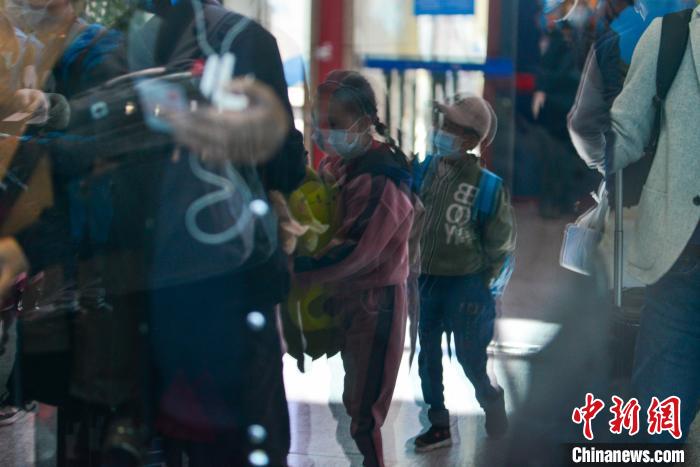 一位孩子抱着玩具走出机场。　江飞波 摄