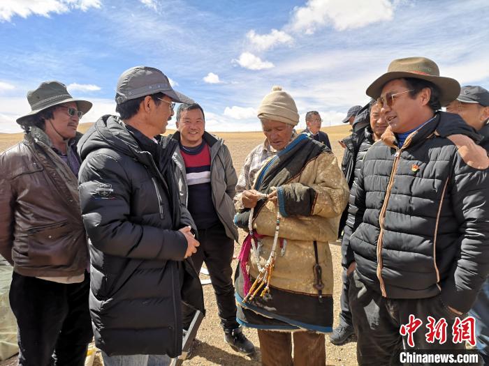 图为尼玛扎西(左二)在阿里调研时和农民聊天(资料图)。西藏农科院 供图