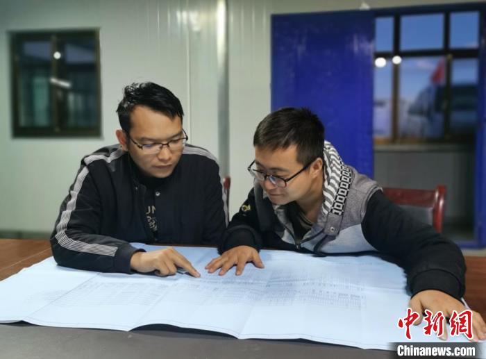 图为金永贵和同事商讨设计方案。(资料图)中国能建甘肃院供图