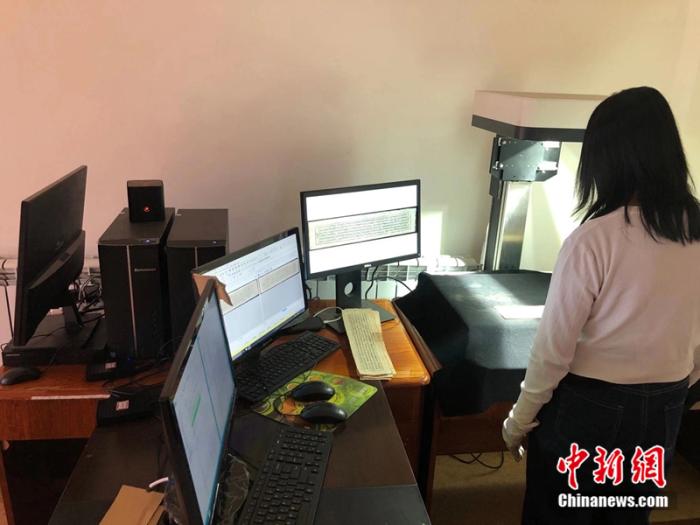 图为工作人员在藏文古籍数字化扫描工作室开展工作。受访者供图