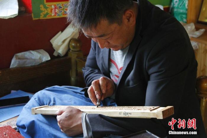 图为7月14日，普松雕刻技艺传承人嘎玛曲扎正在家中进行创作。 <a target='_blank' href='http://www.chinanews.com/'><p  align=