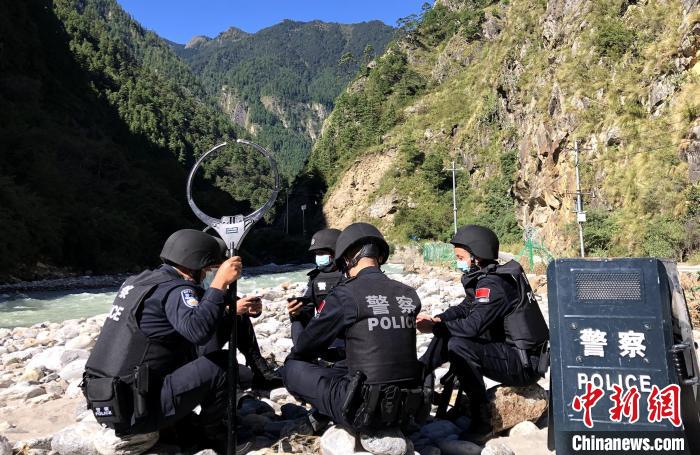 图为西藏吉隆出入境边防检查站移民管理警察在中尼边境巡逻途中收看二十大开幕直播。　郭章统 摄