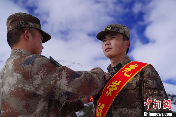 排长王朝伟(图左)给退伍老兵佩戴大红花。　西藏山南军分区某团供图
