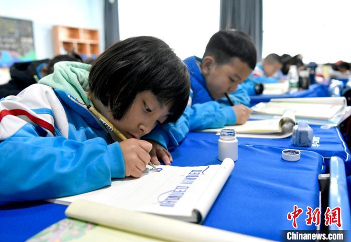 3月14日，西藏拉萨市第一小学一年级六班的学生们在藏语文课上书写藏文。　李林 摄