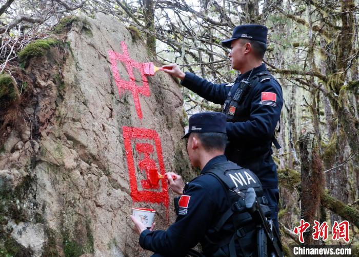 山南边境管理支队玉麦边境派出所民警边境巡逻途中在石头上用油漆涂写“中国”二字 。　郑琦山 摄