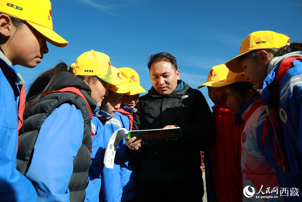 西藏自治区藏医院专家为拉东村小学生讲解天文历算原理，孩子们围站聆听，感受传统智慧与现代科普的融合。人民网记者 吴雨仁摄