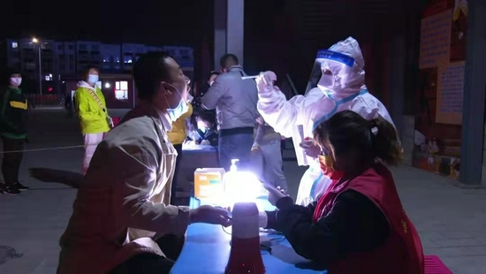 金凤区阳光美林小区工作人员正在为居民做核酸检测。