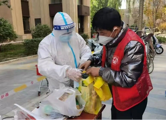 西夏区党员志愿者协助医护人员准备核酸检测用品。