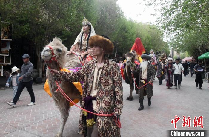 图为丝路驼队在喀什古城景区的街巷展演。　孙亭文 摄